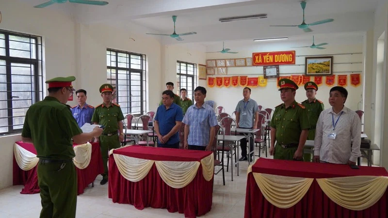 Cơ quan cảnh sát điều tra thi hành quyết định khởi tố đối với hai lãnh đạo xã Yến Dương. (Ảnh: THUỲ DƯƠNG).