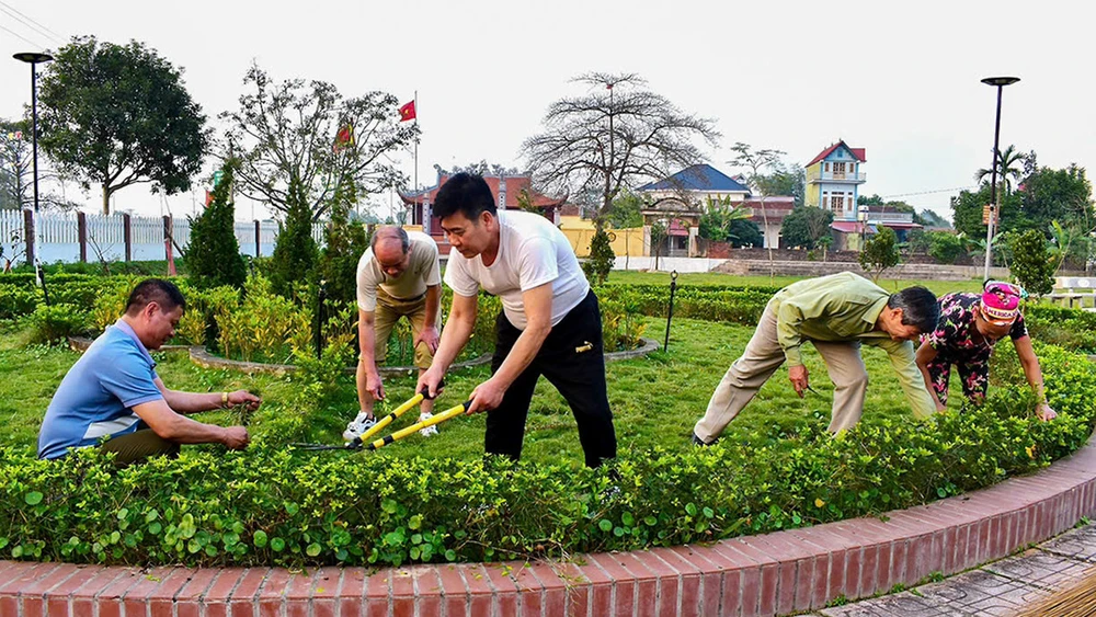 Người dân thôn Đông Am Vàng, xã Việt Lập, huyện Tân Yên (Bắc Giang) cắt tỉa cây xanh trong khuôn viên, góp phần xây dựng nông thôn mới kiểu mẫu. (Ảnh DƯƠNG THỦY)