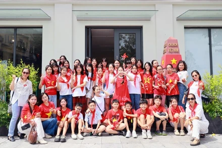 Các em học sinh chụp ảnh lưu niệm tại mô hình cột mốc Trường Sa ở Trung tâm Thông tin văn hóa Hồ Gươm.