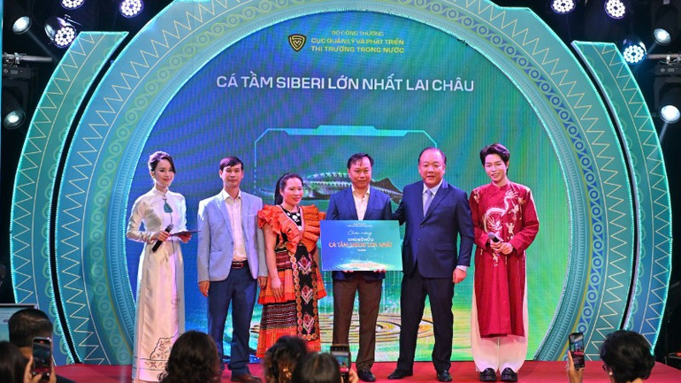 Người chiến thắng trong phiên đấu giá con cá tầm nặng 50 kg nhận biểu trưng chiến thắng từ Ban tổ chức sự kiện. z7151409110799-56d8e4ff927243d8c63dd4fd6dad2200-6431.jpg