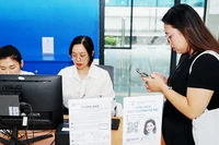 Công nghệ số trợ giúp người dân khi đi làm các thủ tục hành chính. Ảnh: NAM ANH