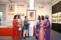 Nhà báo Huỳnh Dũng Nhân (thứ ba, trái sang) giới thiệu bức vẽ kỷ vật gia đình trao tặng Bảo tàng Phụ nữ Việt Nam.