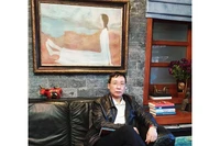 Nhà sưu tầm Hoàng Anh Tuấn bên tác phẩm của họa sĩ Dương Bích Liên.