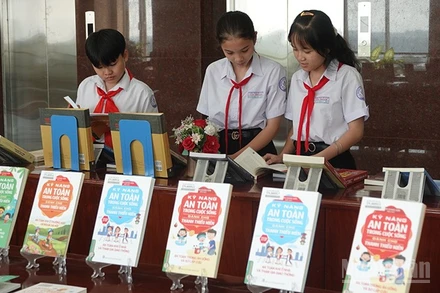 Các bạn nhỏ đang xem sách được trưng bày tại chương trình. (Ảnh: BẢO LINH)