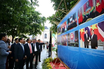 Các đại biểu tham quan triển lãm ảnh. (Ảnh Thanh Vũ)