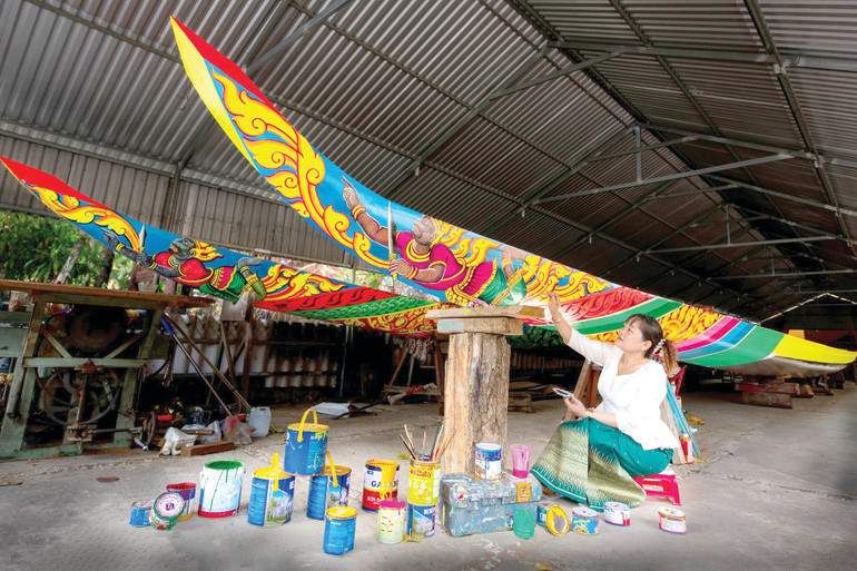 Nghệ nhân Sơn Sà The tỉ mỉ hoàn thiện hoa văn trang trí trên thân ghe ngo, công đoạn đòi hỏi sự khéo léo và am hiểu họa tiết dân gian Khmer. 5.jpg