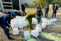 Tiêu hủy rượu không rõ nguồn gốc tại phường Nghĩa Lộ, tỉnh Lào Cai. (Ảnh: THANH SƠN)