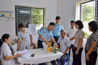 Đại diện lãnh đạo phường Tùng Thiện và Học viện Phòng không-Không quân khám bệnh, cấp thuốc miễn phí cho người có công. 