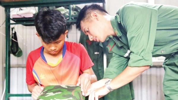 Hồ Lanh được chiến sĩ biên phòng hướng dẫn gấp chăn, gối trước khi về nội trú ở trường học mới.