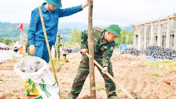 Cán bộ, chiến sĩ Đại đội Bộ binh 1 cùng lực lượng xung kích giúp người dân xây dựng khu tái định cư tại xã Ia Hiao.