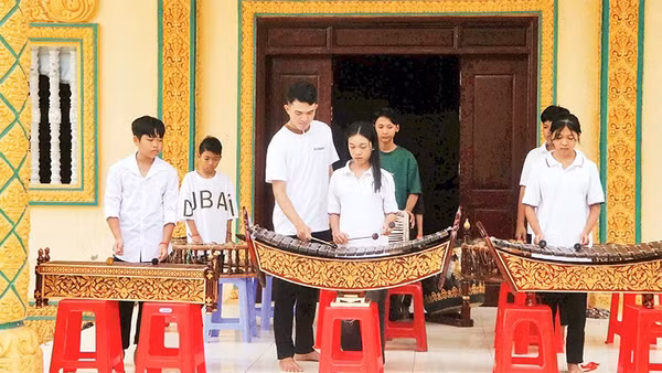Anh Danh Nghiệp hướng dẫn các em chơi nhạc ngũ âm tại chùa Sóc Sâu.