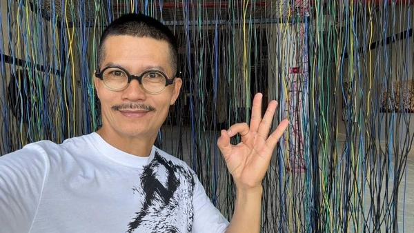 Họa sĩ Nguyễn Ngọc Dân tại triển lãm trưng bày tác phẩm của anh.