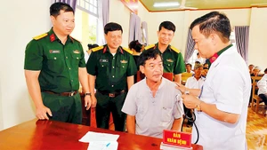 Lãnh đạo Trung đoàn 719 và bác sĩ Bệnh xá Quân dân y thăm hỏi và khám bệnh cho nhân dân.