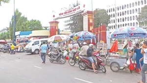 Cổng Bệnh viện Bệnh Nhiệt Đới trở thành chợ bán hàng rong, ảnh hưởng nghiêm trọng đến giao thông.