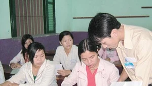 Ðối chiếu ảnh với chứng minh nhân dân, phiếu báo thi trước giờ thi tại điểm thi Trường Lê Quý Ðôn.