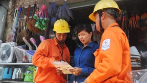 Công nhân ngành điện Thủ đô tuyên truyền, vận động người dân sử dụng điện an toàn, hiệu quả, phòng chống cháy nổ. Ảnh: TOÀN THẮNG