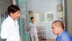 Bác sĩ Nguyễn Chí Thành đang trò chuyện với bệnh nhân. 