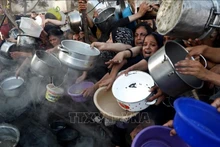 Người dân Palestine chờ được phát thực phẩm cứu trợ tại Gaza. (Ảnh: THX/TTXVN)