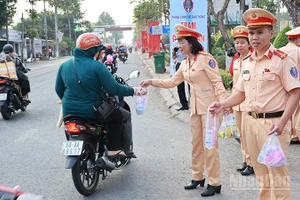 Các lực lượng phát nước suối và khăn lạnh tặng người dân về quê đón Tết.
