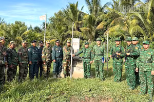 Cán bộ, chiến sĩ 2 bên chụp hình lưu niệm tại cột mốc trong đợt tuần tra song phương.