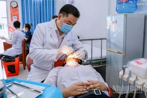 Bác sĩ chuyên khoa II Phạm Kim Thành khám bệnh cho học sinh trường nuôi dạy trẻ khuyết tật tỉnh Đồng Tháp.