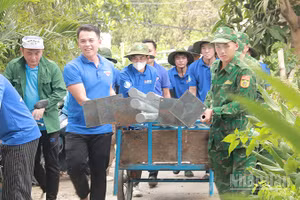 Đoàn viên, thanh niên Đồn Biên phòng Cầu Muống phối hợp cùng Phường đoàn Thường Lạc và đội hình “Mùa hè xanh” của Trường cao đẳng Công nghệ Thủ Đức vận chuyển trụ đèn thực hiện Công trình thắp sáng đường quê. (Ảnh: Phường đoàn Thường Lạc)