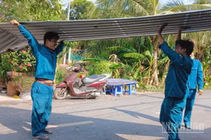 Lực lượng chức năng xã Tân Long giúp người dân lợp lại mái nhà do ảnh hưởng dông lốc.
