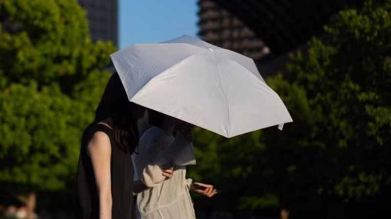 Người dân che ô đi bộ trên phố ở Tokyo, Nhật Bản, ngày 18/6/2025. (Ảnh minh họa: Xinhua)