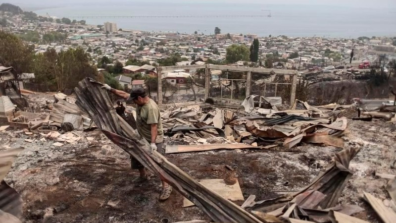 Người dân dọn dẹp khu vực bị ảnh hưởng bởi hỏa hoạn ở Penco, Biobio, Chile, ngày 19/1/2026. (Ảnh: Xinhua)