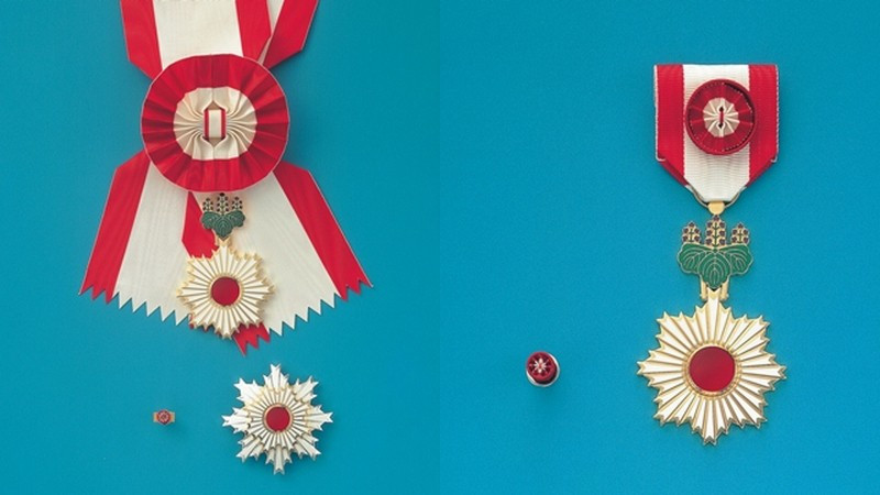 Huân chương Mặt trời mọc hạng nhất Đại Thập tự (trái) và Huân chương Mặt trời mọc có tia sáng vàng và nơ thắt hoa hồng (phải) của Nhật Bản. (Ảnh: Văn phòng Nội các Nhật Bản)