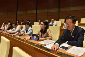 Các đại biểu Quốc hội đoàn Đồng Nai bấm nút biểu quyết Luật Thư viện. (ẢNH: DUY LINH)