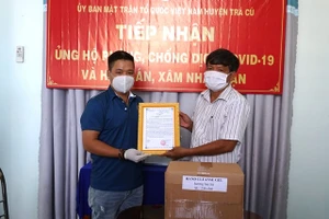 Lãnh đạo UBMTTQVN huyện Trà Cú trao thư cảm ơn cho đơn vị tài trợ.