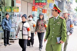 Công an phường Hàng Bài (quận Hoàn Kiếm) phối hợp lực lượng bảo vệ dân phố, tự quản chuyên trách thường xuyên tuần tra, nhắc nhở các hộ kinh doanh không lấn chiếm vỉa hè, lòng đường. Ảnh: NGÂN HẠ