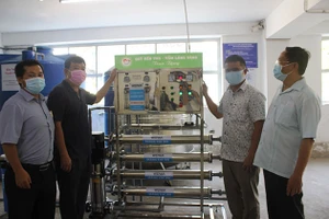 Lãnh đạo chính quyền địa phương tiếp nhận máy lọc nước mặn thành nước ngọt từ đơn vị tài trợ.