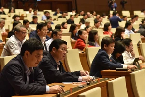 Các đại biểu Quộc hội bấm nút biểu quyết chiều 26-11. (ẢNH: DUY LINH)