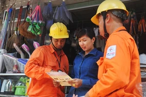 Công nhân ngành điện Thủ đô tuyên truyền, vận động người dân sử dụng điện an toàn, hiệu quả, phòng chống cháy nổ. Ảnh: TOÀN THẮNG