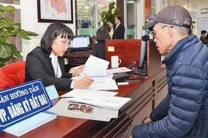 Hướng dẫn người dân hoàn thiện hồ sơ cấp giấy chứng nhận quyền sử dụng đất tại Văn phòng đăng ký đất đai Hà Nội - chi nhánh quận Nam Từ Liêm. Ảnh: DUY LINH