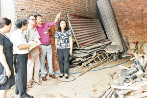 Cán bộ Phòng Lao động - Thương binh và Xã hội quận Ðống Ða kiểm tra công trình xây dựng nhà cho người có công tại phường Cát Linh. Ảnh: Ðăng Anh