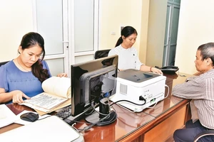 Cán bộ bộ phận một cửa quận ủy Thanh Xuân giải quyết thủ tục hành chính về công tác Đảng cho đảng viên.