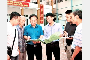 Cán bộ MTTQ phường Yết Kiêu, quận Hà Đông (Hà Nội) trao đổi, giám sát công việc cải tạo một công trình văn hóa. Ảnh: BÁ HOẠT