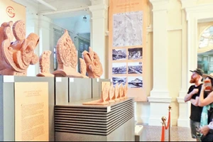 Khách nước ngoài xem bộ sưu tập phiên bản hiện vật.