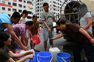 Nhiều hộ dân xếp hàng để lấy nước tại tòa chung cư HH thuộc Khu đô thị Linh Đàm, quận Hoàng Mai, Hà Nội (Ảnh: Thủy Nguyên).