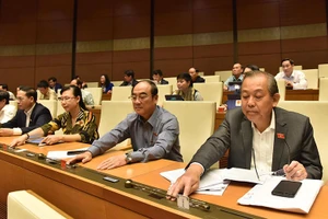 Các đại biểu bấm nút thông qua Luật Chứng khoán (sửa đổi). (ẢNH: DUY LINH)