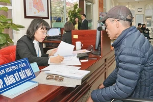 Cán bộ bộ phận "một cửa" UBND quận Nam Từ Liêm hướng dẫn người dân đến làm thủ tục hành chính.