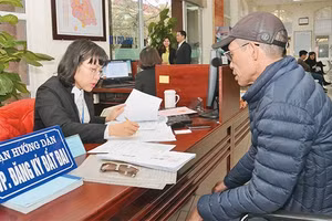 Cán bộ bộ phận "một cửa" UBND quận Nam Từ Liêm hướng dẫn người dân đến làm thủ tục hành chính.