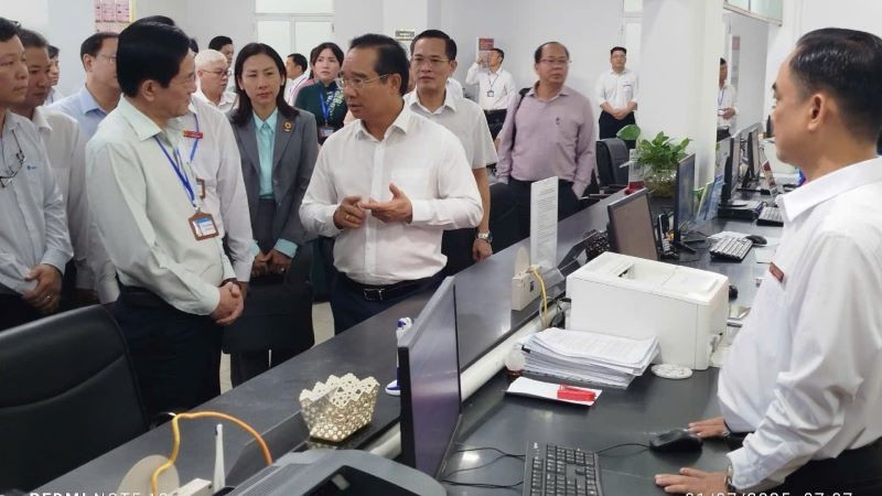 Chủ tịch Ủy ban nhân dân Thành phố Hồ Chí Minh Nguyễn Văn Được trao đổi với Bí thư phường Dĩ An Võ Văn Hồng về hoạt động của Trung tâm phục vụ hành chính công phường Dĩ An. tp1.jpg