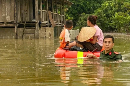 Công an xã Yên Bình đưa người dân ra khỏi khu vực bị ngập lụt.