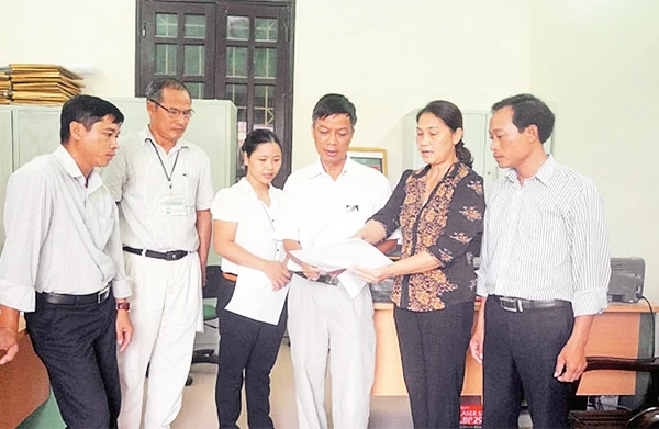 Cán bộ Ủy ban MTTQ phường Giang Biên (quận Long Biên) thảo luận việc triển khai giám sát, nhận xét đảng viên hai chiều tại nơi cư trú. Ảnh: TUỆ PHƯƠNG