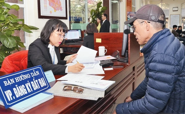 Hướng dẫn người dân hoàn thiện hồ sơ cấp giấy chứng nhận quyền sử dụng đất tại Văn phòng đăng ký đất đai Hà Nội - chi nhánh quận Nam Từ Liêm. Ảnh: DUY LINH