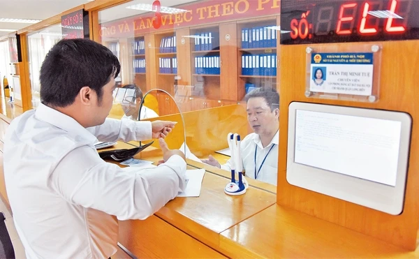 Giải quyết thủ tục hành chính cho người dân tại Bộ phận một cửa UBND quận Long Biên. Ảnh: MINH HÀ